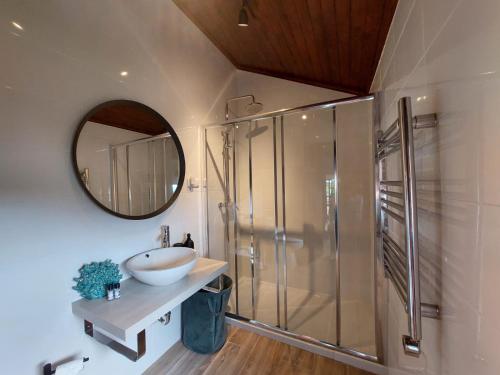 a bathroom with a sink and a shower with a mirror at Casa de Gandra in Valença