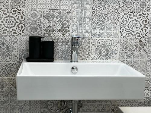 Baño con lavabo blanco y papel pintado en Marzamemi, Sul Livello del MARE, Spinazza en Marzamemi