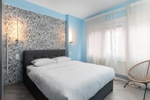 - une chambre avec un grand lit aux murs bleus dans l'établissement #Amazonia Apt by halu! Apartments, à Thessalonique