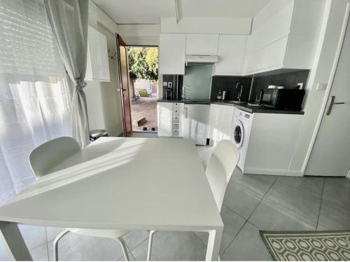 a white kitchen with a white table and chairs at Jean Paul 2 Au cœur de Rouen , gare "Ménage & Linge Inclus" in Rouen