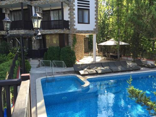 a swimming pool in front of a house at The Green Paradise Apartments in Primorsko