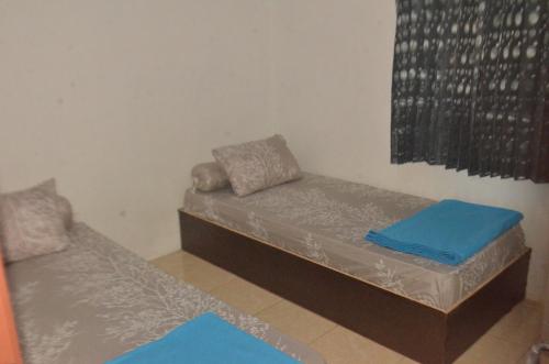 two beds in a room with blue mats on them at Baronda Guest House in Sorong