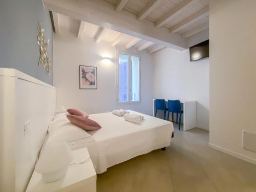 a white bedroom with a bed and blue chairs at Le Stanze di Gianmarmo - Via Marsala in Mirandola