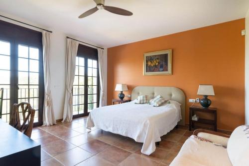 una camera da letto con un letto con pareti e finestre arancioni di Villa Pantanal in Golf Costa Brava a Santa Cristina d'Aro
