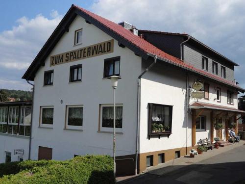 un edificio blanco con un cartel en el costado en Gasthaus Zum Spalterwald, en Beerfelden