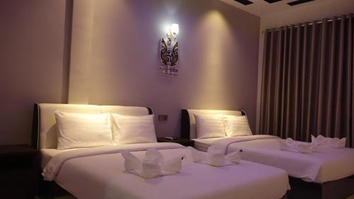 2 camas en una habitación de hotel con almohadas blancas en Suorsdei Boutique, en Kampot