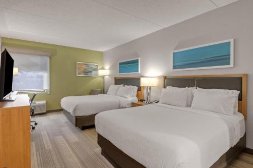 a hotel room with two beds and a flat screen tv at Holiday Inn Express Hershey-Harrisburg Area by IHG in Hershey