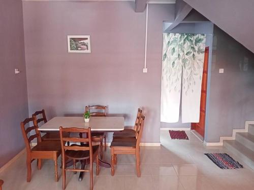 comedor con mesa, sillas y ventana en double storey cosy home pengkalan balak 5 aircond, en Pengkalan Balak