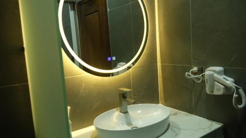 y baño con lavabo blanco y espejo. en Suorsdei Boutique, en Kampot