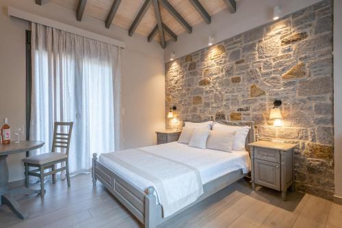 1 dormitorio con cama y pared de piedra en AMYGDALIES STONE APARTMENTS en Mirina
