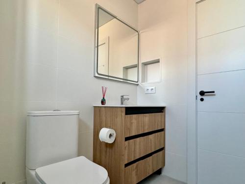 ein Badezimmer mit Toilette und Spiegel in der Unterkunft Apartamento Bonita Vista in Vinarós