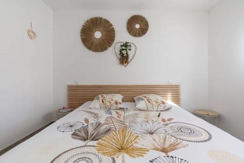 - une chambre dotée d'un lit avec un couvre-lit floral et des miroirs dans l'établissement The Chill House Grau d'Agde, au Grau-dʼAgde
