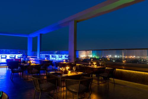 a restaurant with tables and chairs at night at Holiday Inn Lucknow Airport by IHG in Lucknow