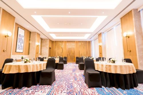 a conference room with tables and chairs in it at Holiday Inn Lucknow Airport by IHG in Lucknow