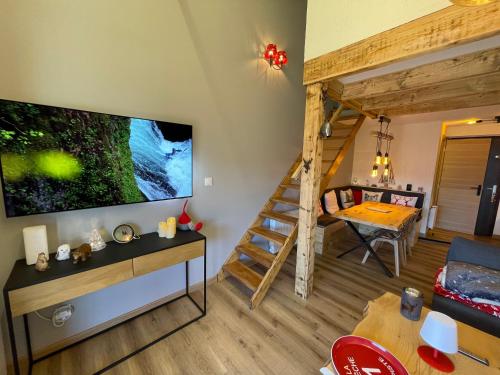 un salon avec une grande télévision à écran plat et un escalier dans l'établissement Bonascre comme au Chalet, à Ax-les-Thermes