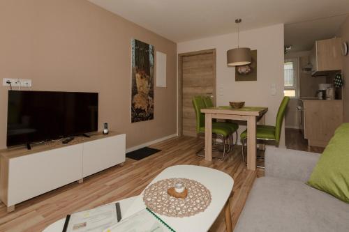 een woonkamer met een flatscreen-tv en een tafel bij Ferienhaus Biber im Sternenpark in Lochow