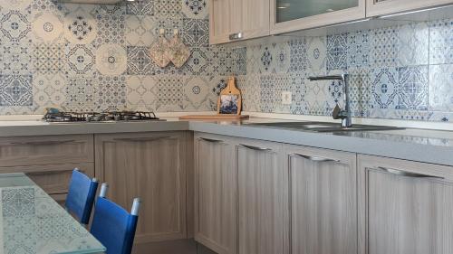 una cocina con armarios de madera y azulejos azules y blancos en Marzamemi, Sul Livello del MARE, GOLD en Marzamemi