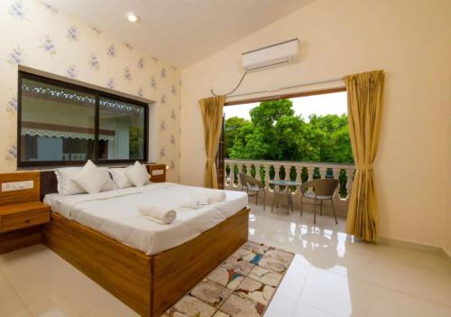 a bedroom with a bed and a large window at STAR HOLIDAY VILLAS in Anjuna