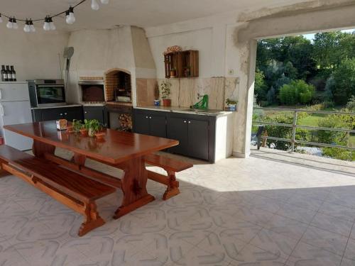 uma cozinha com uma mesa de madeira e uma grande janela em Comfortabel downstairs appartment close to Coimbra em Vila Nova de Poiares