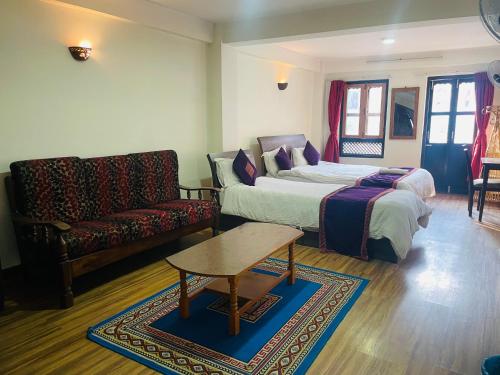 a living room with a bed and a couch at Hotel Bhaktapur Inn in Bhaktapur