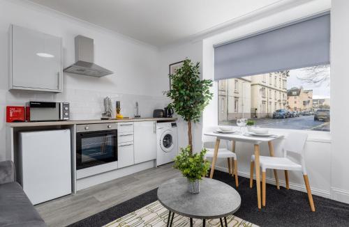 a living room with a table and a kitchen at South Inch Apartment in Perth
