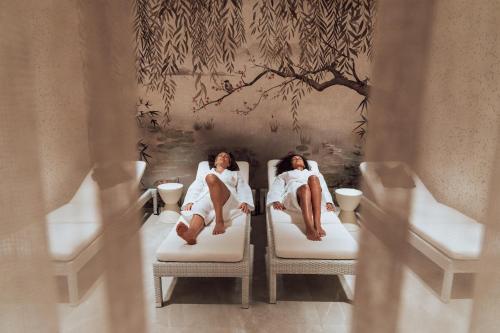 two women sitting in beds in a room at RAJ zdravia in Bratislava