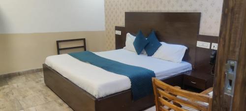 ein Schlafzimmer mit einem großen Bett mit blauen Kissen in der Unterkunft HOTEL ONYX in Zirakpur