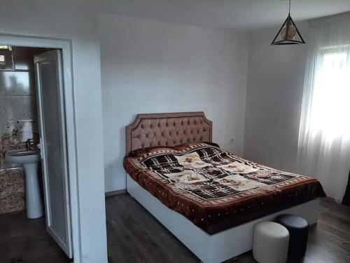 a bedroom with a bed in a room with a window at ლამაზი სახლი და სასიამოვნო გარემო სტუმრებისთვის in Batumi
