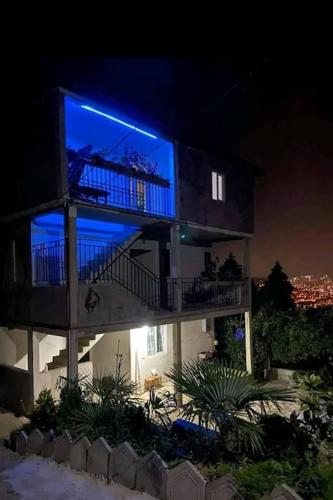 a building with a blue light on the side of it at ლამაზი სახლი და სასიამოვნო გარემო სტუმრებისთვის in Batumi