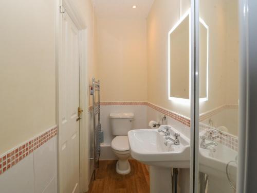 a white bathroom with a sink and a toilet at Castell in Pwllheli