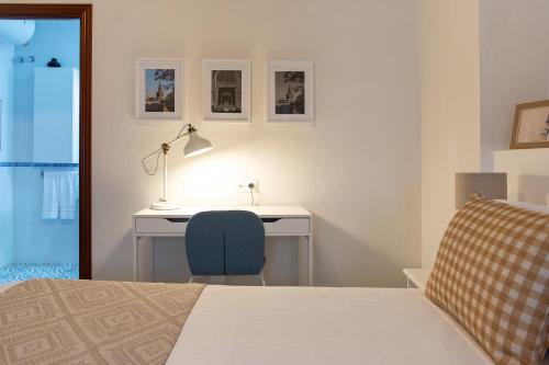1 dormitorio con escritorio, 1 cama y 1 silla en Apartamentos San Francisco, en Sevilla