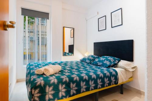 a bedroom with a bed with a blue blanket at San Pagés 3BR Apartment in Seville