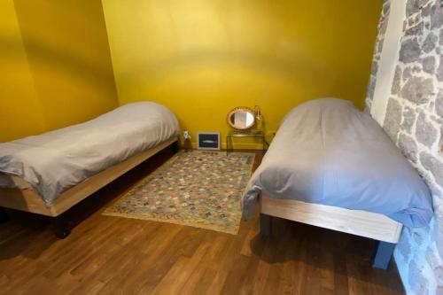 Cette petite chambre comprend 2 lits et un tapis. dans l'établissement Appartement à 30m de la plage du Sillon., à Saint-Malo