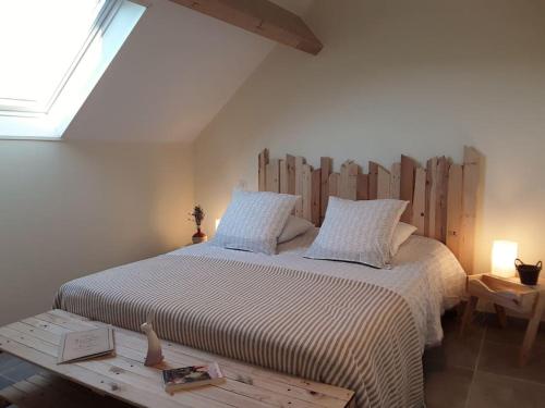 une chambre avec un grand lit avec une tête de lit en bois dans l'établissement Le Jardin de l'Albert, à Beurey-Bauguay