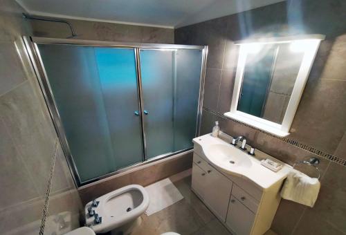 a bathroom with a sink and a toilet and a mirror at Casa Simona Villa General Belgrano in Villa General Belgrano
