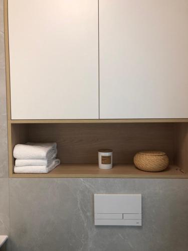 ein Badezimmerregal mit einem weißen Schrank und Handtüchern in der Unterkunft Black Pearl DeLuxe Apartments City View in Stettin