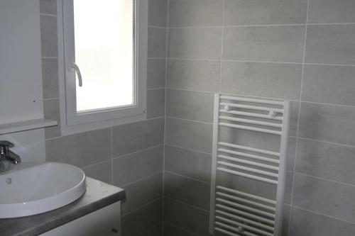 une salle de bain avec un lavabo et des toilettes et une fenêtre dans l'établissement Villa la garenne : Chausey, à La Bernerie-en-Retz
