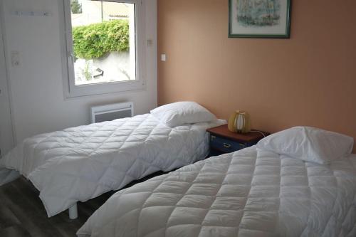 une chambre avec deux lits et une fenêtre dans l'établissement Villa la garenne : Chausey, à La Bernerie-en-Retz