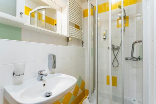 a bathroom with a sink and a shower at Complex Curie in Jáchymov