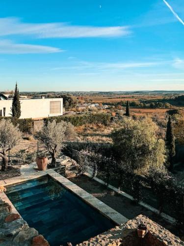 une piscine au milieu d'un champ dans l'établissement Maison d'hôtes Les Oliviers, à Cazouls-lès-Béziers