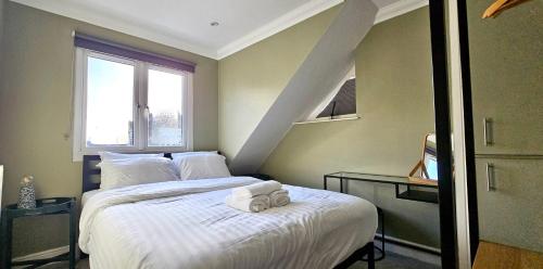 Un dormitorio con una cama con dos toallas encima. en Victoria House by Switchback Stays, en Cardiff