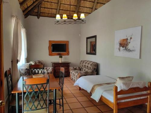 a living room with a bed and a couch and a table at La Campagna Olive Estate in Modimolle