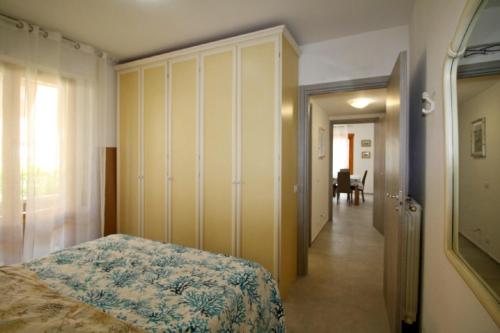 ein Schlafzimmer mit einem Bett und einer Tür zu einem Flur in der Unterkunft Navigatore in Marina di Grosseto