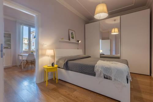 ein Schlafzimmer mit einem großen Bett und einem gelben Tisch in der Unterkunft Bolo Stay Central Apartment in Bologna