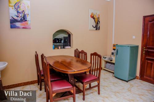 a kitchen with a table and chairs and a refrigerator at Villa Daci in Gulu
