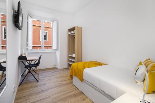 Smart Living Hub: Designer Spaces for Digital Nomads & Remote Workers في لشبونة: غرفة نوم بسرير ومكتب ونافذة