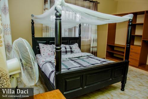 a bedroom with a black bed with a canopy at Villa Daci in Gulu