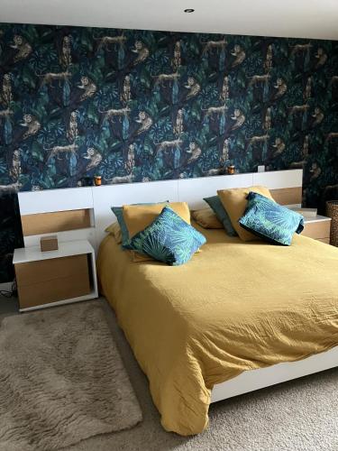 1 dormitorio con 1 cama con almohadas azules y amarillas en villa vue mer cinq chambres Les terrasses des Collines en Le Cannet