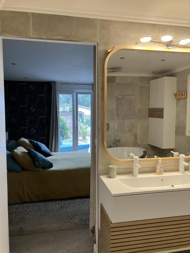 1 dormitorio con cama, espejo y lavamanos en villa vue mer cinq chambres Les terrasses des Collines en Le Cannet