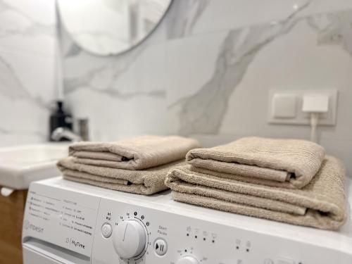 una pila de toallas sobre una lavadora en Hann Horizon Apartments Katowicka 39, en Opole